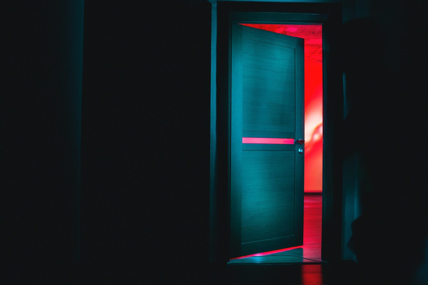 A door open to the dark room with red light.